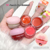 Hand holding small containers of lip gloss with visible brand name 'Gege bear'.