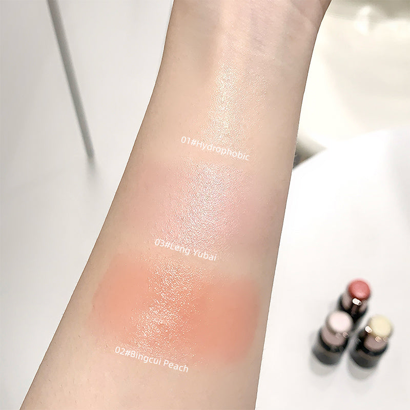 Arm swatches of different makeup products with visible labels on a white background