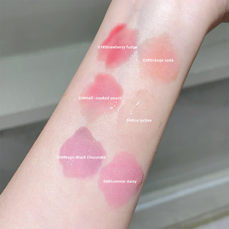Color swatches of lip gloss on a person's arm with labels.