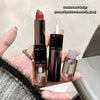 Hand holding two lip products with 'GEGE BEA' branding against a neutral background.