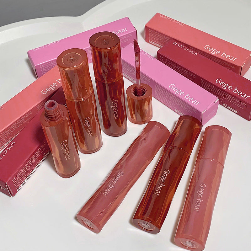 Lip gloss products with 'Geege bear' branding on a white surface