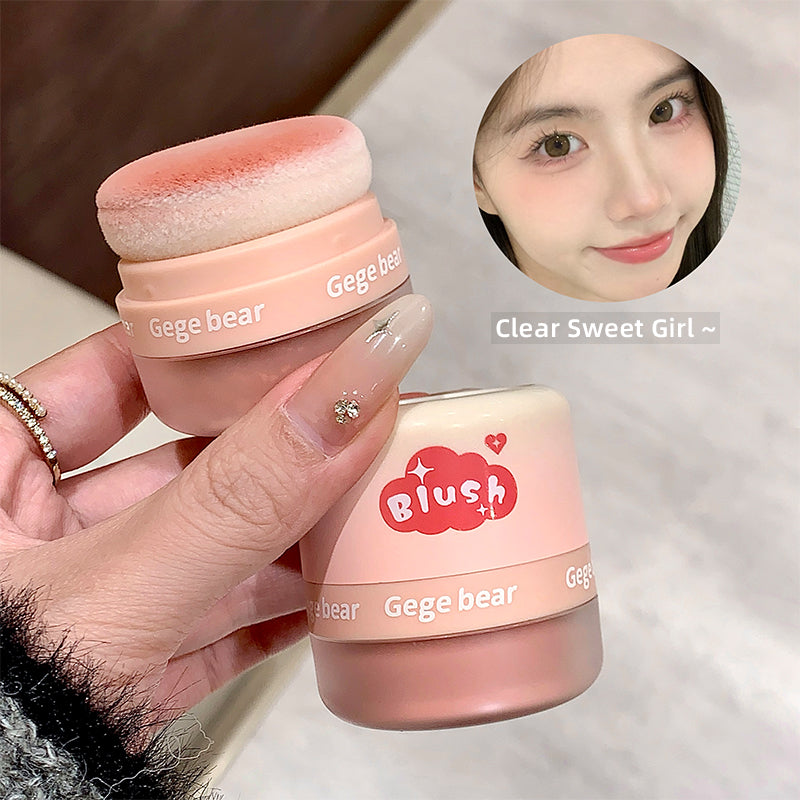 Pink makeup product with 'Gege bear' branding held by a hand, with a blurred face inset.