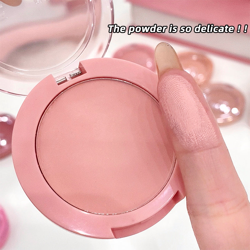 Pink compact powder with a finger touching it, text 'The powder is so delicate!!' on a light pink background.