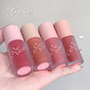 Four lip glosses from the brand 'Gege bear' held in a hand against a gray background.