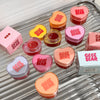 Heart-shaped containers with 'Gee Ge Bear' text on a metallic surface