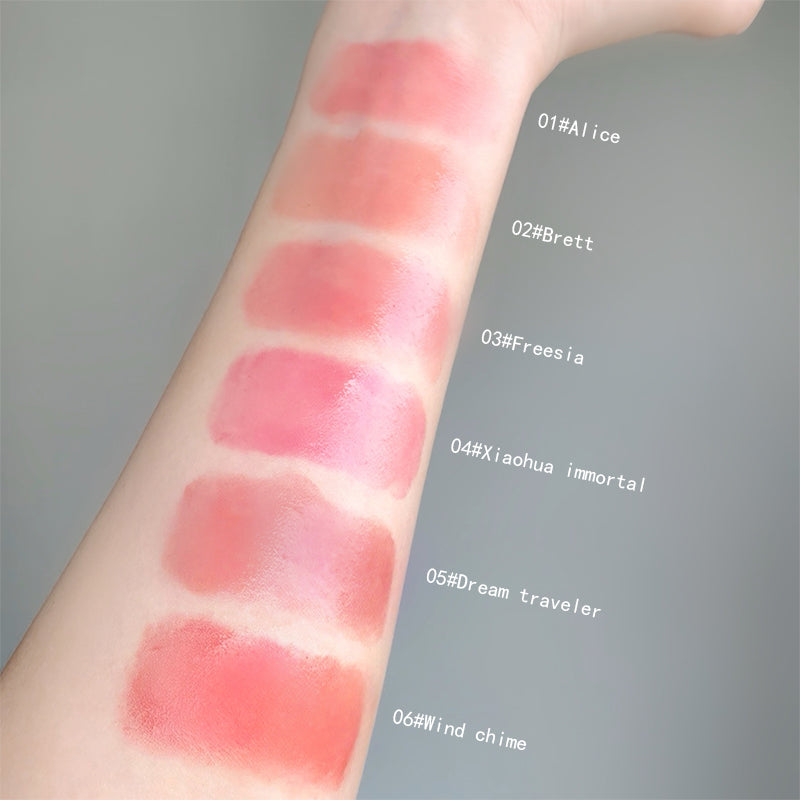 Lipstick swatches on a person's arm with color names labeled.
