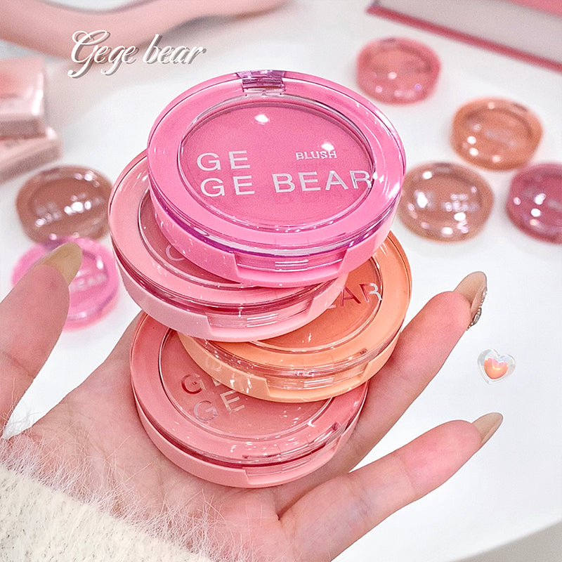 Pink blush compact with 'Ge Ge Bear' branding held in a hand, with more blushes in the background.