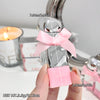 Small silver bottle with pink bow and packaging held by a hand, with measurements and product details displayed.