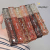 Packaged lip products with 'Gege bear' branding held by a hand against a neutral background.