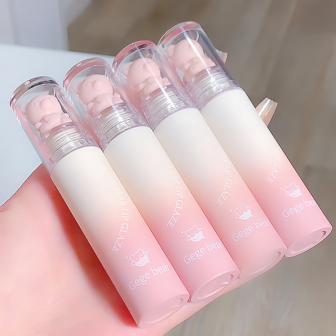 Set of pink and white lip glosses with 'gegebear' branding on a light background