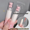 Two lip glosses with bear-shaped caps held by a hand, with text praising the product.