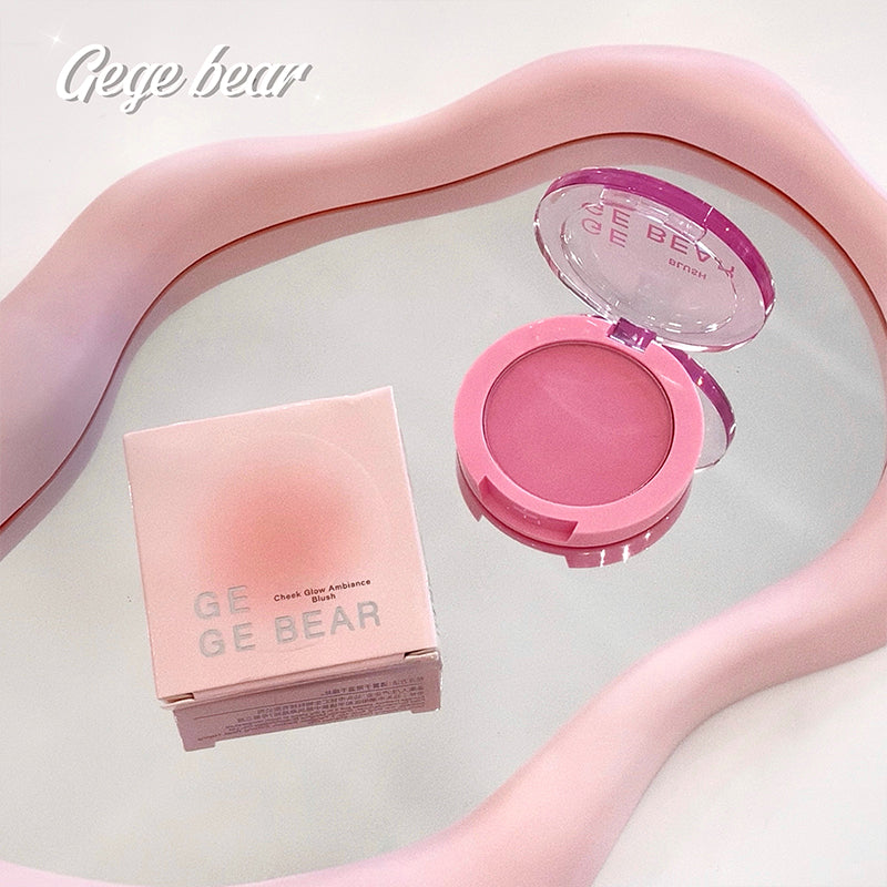 Pink blush compact with open lid on a white surface, branded 'Gee Bear'.