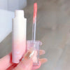 Lip gloss with applicator held by a hand against a neutral background
