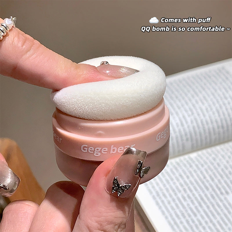 Pink compact with white puff held by a hand, labeled 'Gege beat'.