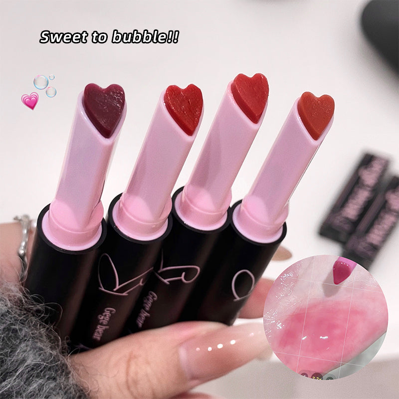 Heart-shaped lipsticks held by a hand with a blurred background