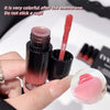 Lip gloss with applicator held by a hand, close-up view.