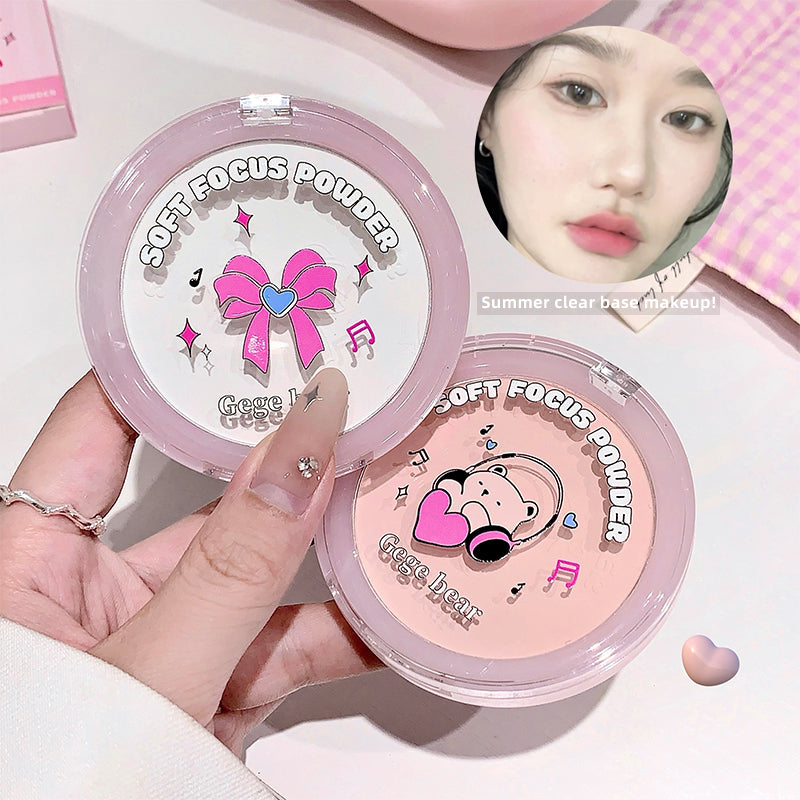 Two compact powder cases with cartoon designs and a hand holding one of them.