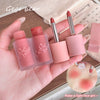 Hand holding pink lip products with 'Gege bear' branding on a wooden surface.