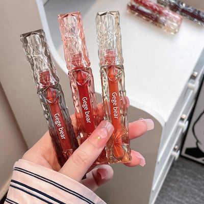 Hand holding three small transparent packages with red contents labeled 'Gege bear'.