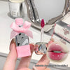 Pink lip gloss with a bow and applicator, held by a hand, with a close-up of lips wearing the gloss.