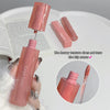 Pink lip gloss with applicator held by a hand, open book in background