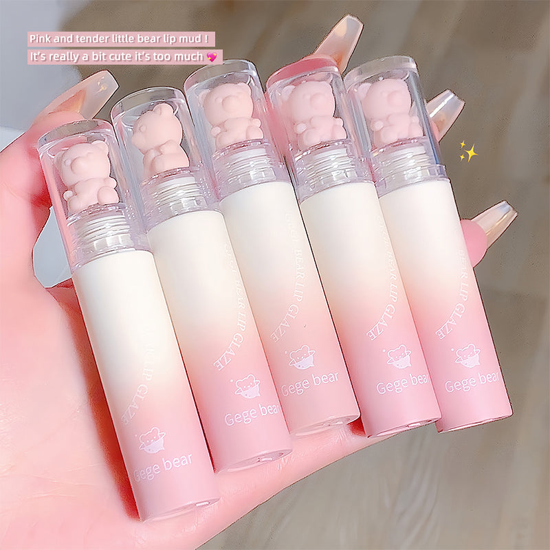 Set of five gradient lip balms with bear-shaped caps held in a hand.