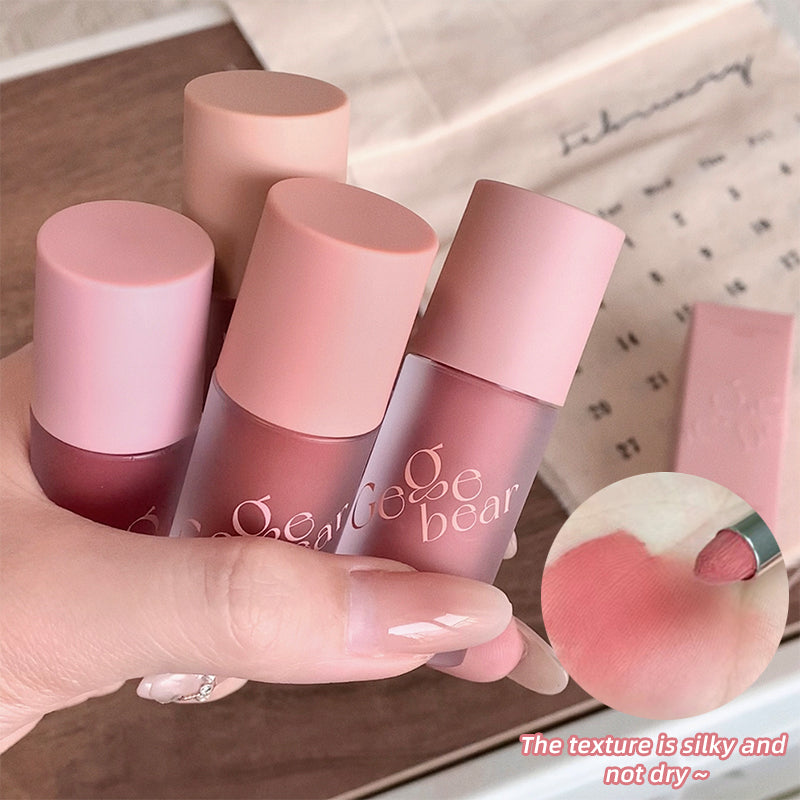 Set of pink lip glosses with visible brand name, held by a hand.