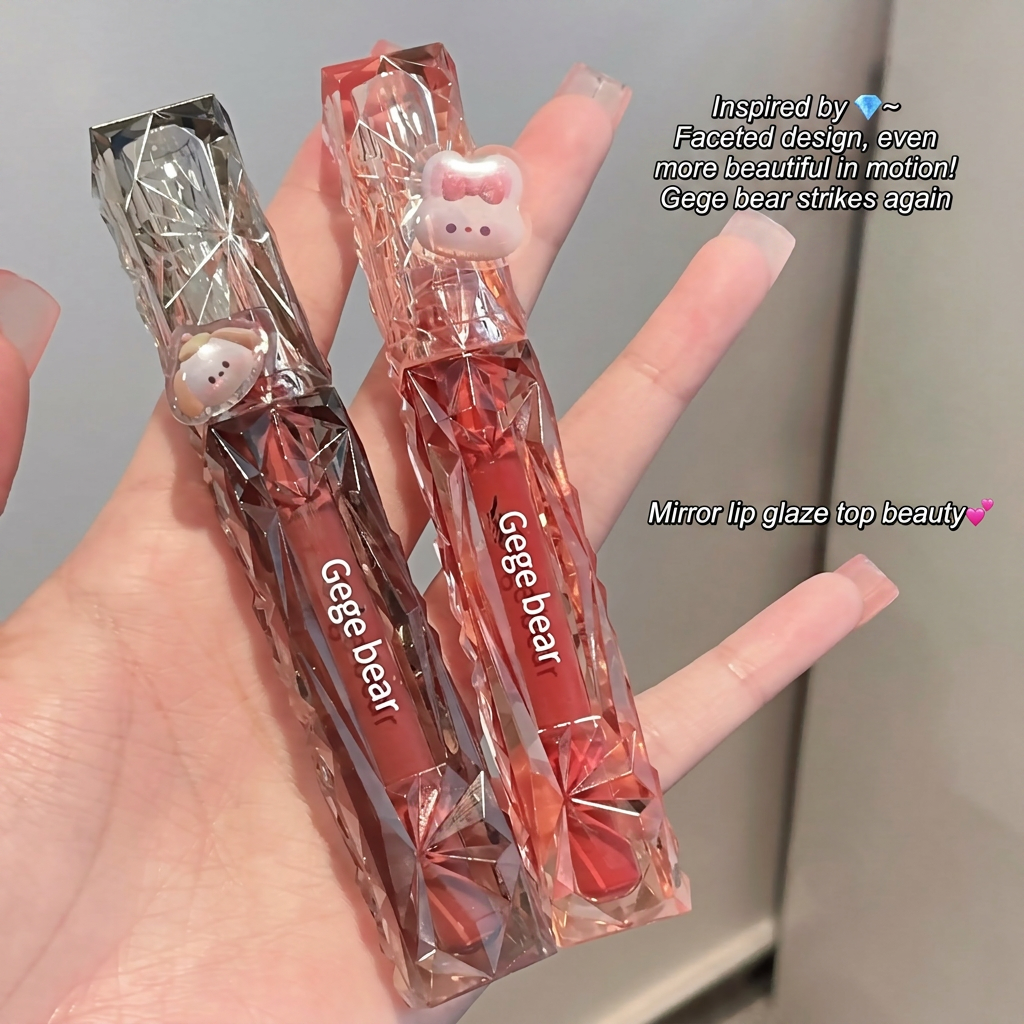 Two Gege bear lip glosses held in a hand with a blurred background
