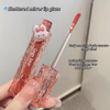 Lip gloss with a cute animal-shaped cap held by a hand, against a neutral background.