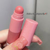 Pink lip balm with a cute crayon tip held by a hand against a gray background