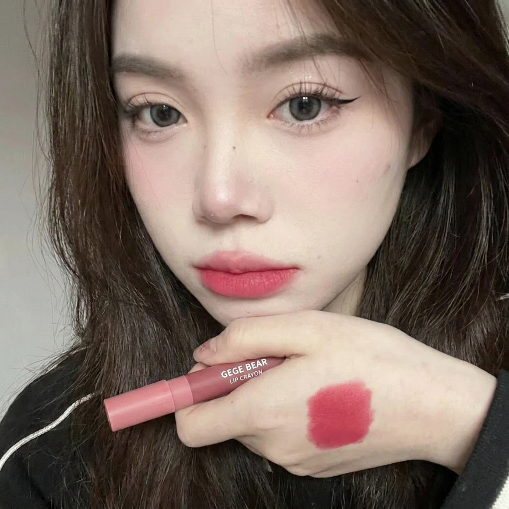 Woman holding a pink lipstick with a swatch on her wrist, featuring the brand 'GEGE BEAR'.