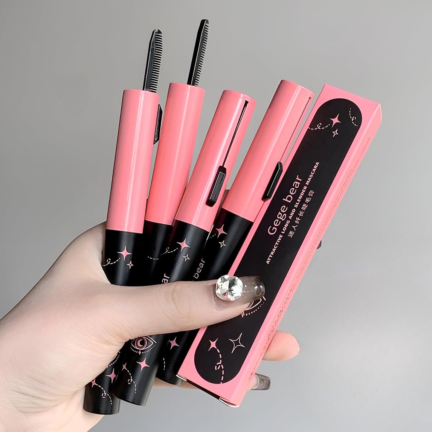 Set of pink and black eyebrow tools with 'Gage Bar' branding held by a hand against a gray background.